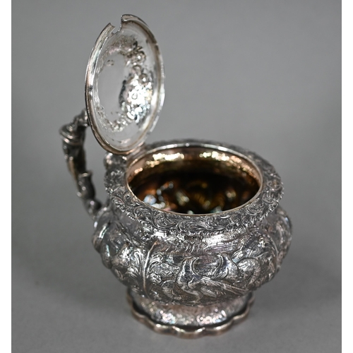 176 - A good George IV silver mustard with hinged cover, scroll handle and stemmed foot, richly embossed a... 