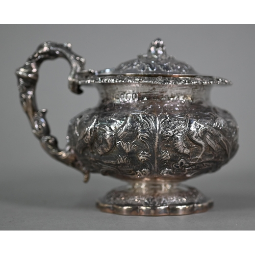 176 - A good George IV silver mustard with hinged cover, scroll handle and stemmed foot, richly embossed a... 