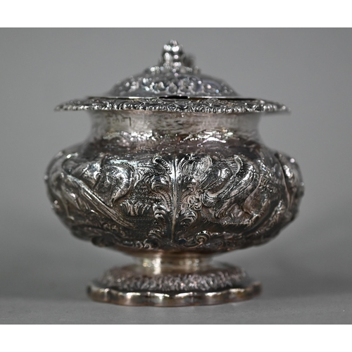 176 - A good George IV silver mustard with hinged cover, scroll handle and stemmed foot, richly embossed a... 