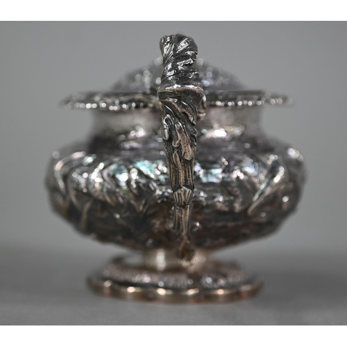 176 - A good George IV silver mustard with hinged cover, scroll handle and stemmed foot, richly embossed a... 