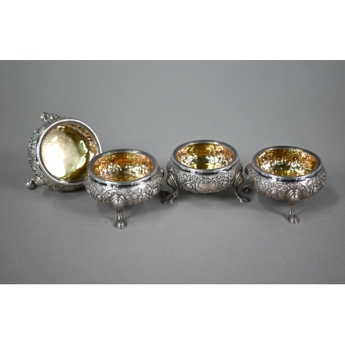 177 - A set of four George II silver circular salts with later floral embossed and chased decoration, on h... 