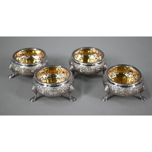 177 - A set of four George II silver circular salts with later floral embossed and chased decoration, on h... 