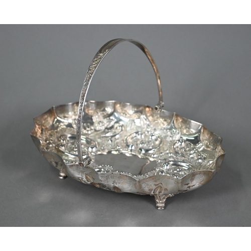 194 - An Edwardian silver basket with swing loop handle, richly embossed and chased with flowers, foliage ... 