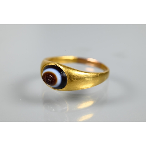 202 - A Roman gold ring set with banded agate intaglio carved with indistinct figures, size U 1/2 (resized... 