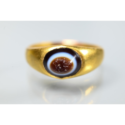 202 - A Roman gold ring set with banded agate intaglio carved with indistinct figures, size U 1/2 (resized... 