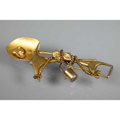 205 - A gold 'prospector' brooch, in the form of crossed spade and pickaxe, suspending a bucket and w... 