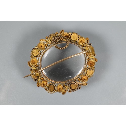 206 - A Victorian gilt metal oval brooch with filigree decoration and set with semi-precious stones/paste,... 