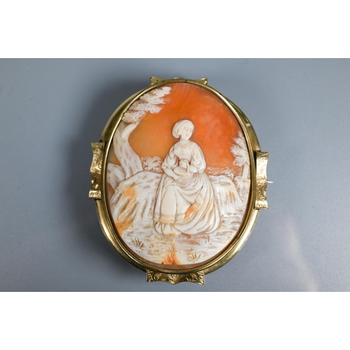 213 - A large Victorian carved shell cameo brooch featuring maiden seated in a landscape, yellow metal mou... 