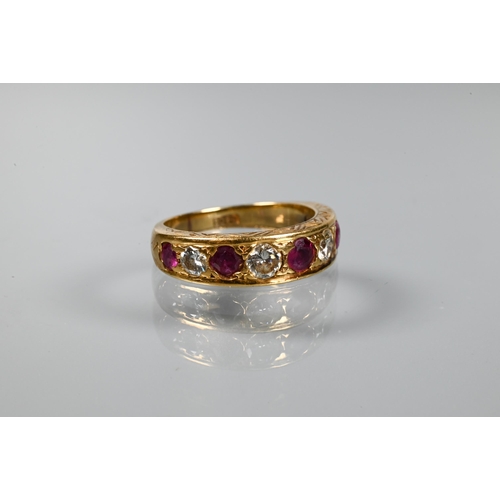 216 - An antique 18ct yellow gold ring set with nine graduated alternate set ruby and diamonds, in carved ... 