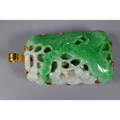 225 - A Chinese jade pendant, the pierced rectangular plaque of moss on snow jade carved with stylised lot... 