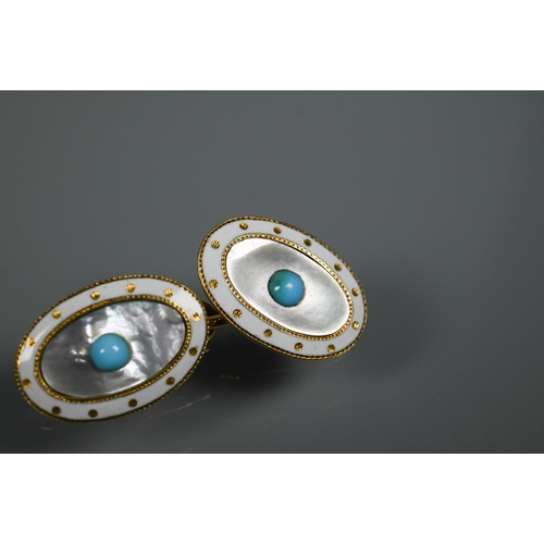 230 - A pair of oval chain-linked cufflinks with white enamel and mother of pearl decoration, the centre s... 