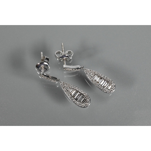 233 - A pair of modern 18ct white gold and diamond drop earrings, the tear drop baguette and brilliant cut... 