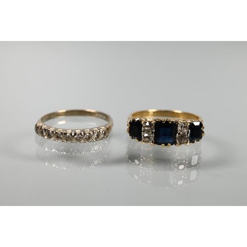 236 - An 18ct yellow gold ring set with three graduated rectangular dark blue sapphires with diamonds betw... 