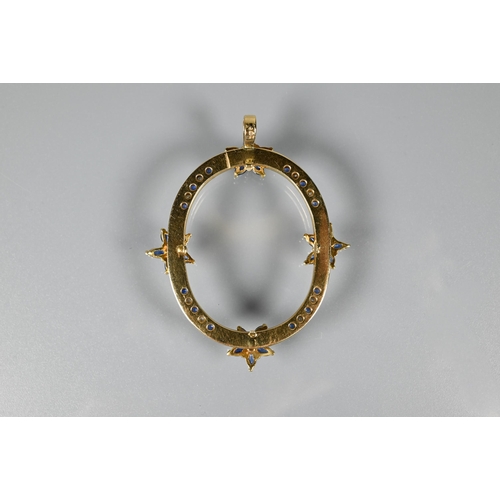 237 - An oval pendant, with mount fittings, set with four sapphire and diamond clusters and with sapphire ... 