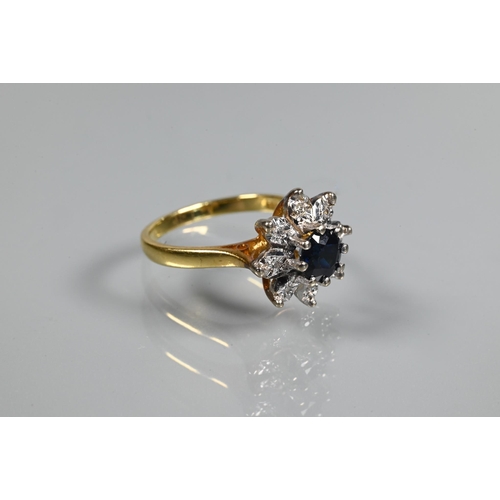 240 - A diamond and sapphire cluster ring, the central circular claw set blue sapphire with eight small di... 