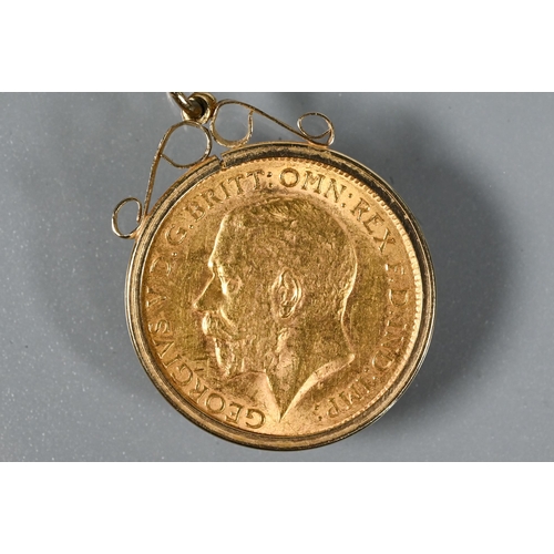 243 - A George V half sovereign dated 1914 in scroll mount, on 9ct yellow gold chain, approx 7.5g all in