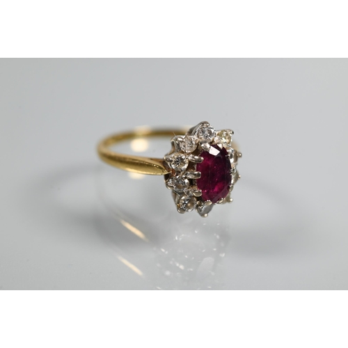 249 - A ruby and diamond cluster ring, the oval ruby with ten claw set diamonds around, 18ct yellow gold s... 