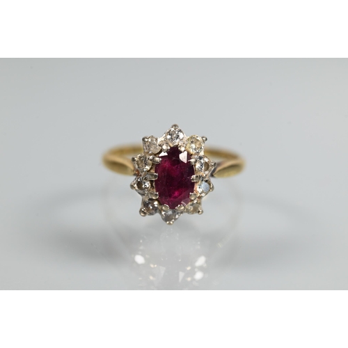 249 - A ruby and diamond cluster ring, the oval ruby with ten claw set diamonds around, 18ct yellow gold s... 