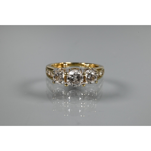 266 - A three-stone diamond ring, the three round claw set brilliant cut diamonds in raised setting above ... 