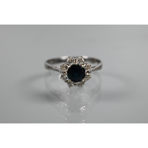 272 - A ring set circular blue sapphire surrounded by eight claw set brilliant cut diamonds, size P