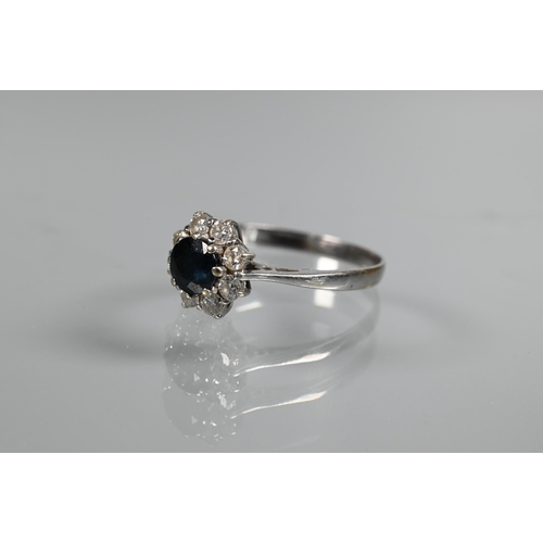 272 - A ring set circular blue sapphire surrounded by eight claw set brilliant cut diamonds, size P