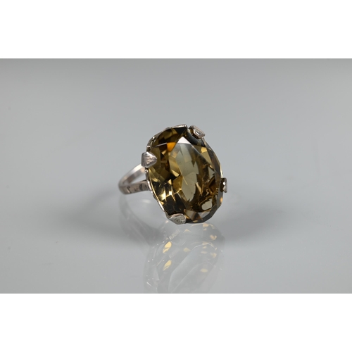 273 - A large oval smokey quartz ring, claw set with silver trellis mount, size O, 2 x 1.5 cm