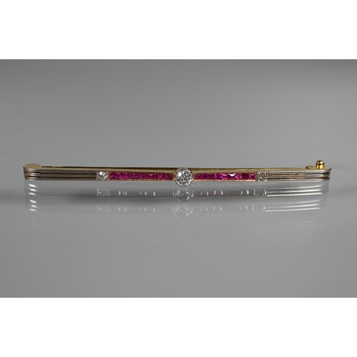 284 - An Art Deco ruby and diamond bar brooch, the calibre set rubies flanking a central millgrain set dia... 