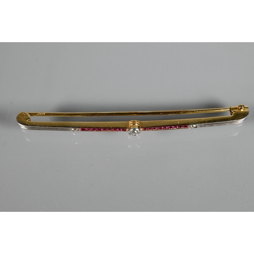 284 - An Art Deco ruby and diamond bar brooch, the calibre set rubies flanking a central millgrain set dia... 