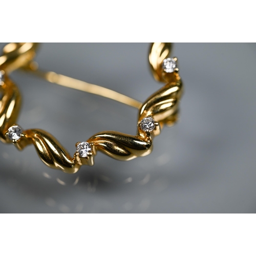 300 - An 18ct yellow gold circlet brooch of scroll circular form, set with eight claw set brilliant cut di... 