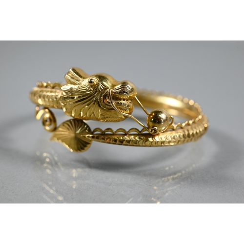 300A - A Chinese yellow gold half-hinged bangle in the form of a coiled dragon chasing the flaming pearl, t... 