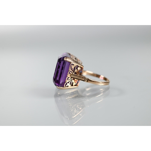 313 - A square amethyst cocktail ring, claw set yellow metal with decorative mount, size O, size 1.8 x 1.8... 