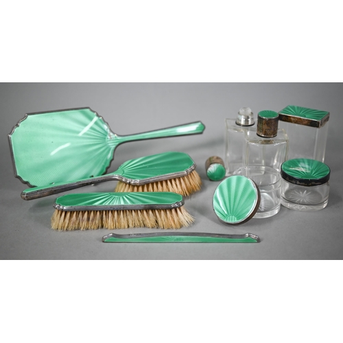 51 - An Art deco silver and green guilloche enamel toilet set, comprising five jars and bottles and a fou... 