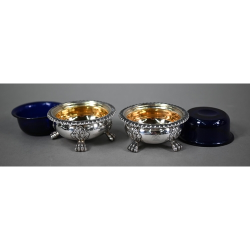 77 - A pair of William IV silver circular open salts in the Regency manner, with blue glass liners and  g... 