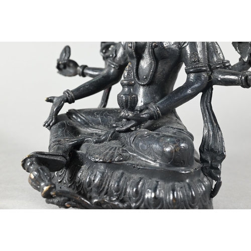 455 - A Nepalese bronze figure of the three-faced Buddhist goddess Vasudhara, seated in royal ease positio... 