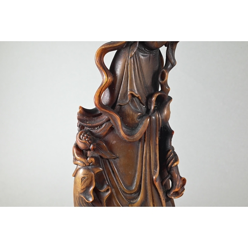 466 - A Chinese carved bovine horn figure of Guanyin (Bodhisattva of compassion) standing in flowing robes... 