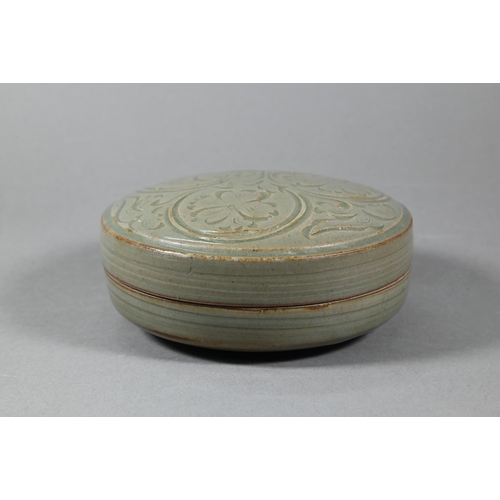 474 - A Chinese celadon circular porcelain box and cover evenly covered with an olive green glaze, the top... 
