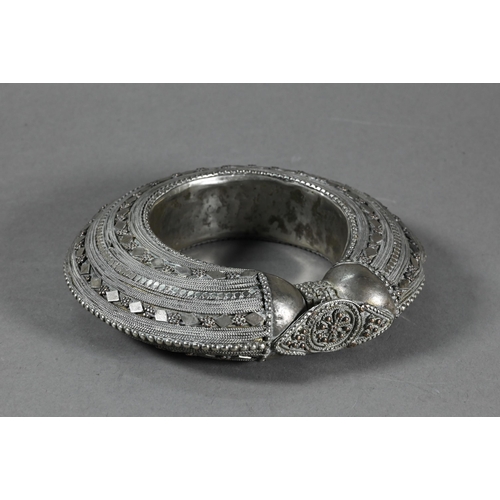 489 - A middle-eastern (probably Yemen) antique low grade silver bangle to/w an antiqued circular metal go... 