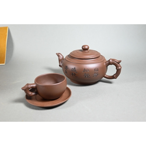 511 - A boxed Chinese Yixing pottery tea set comprising a compressed globular teapot and cover with incise... 