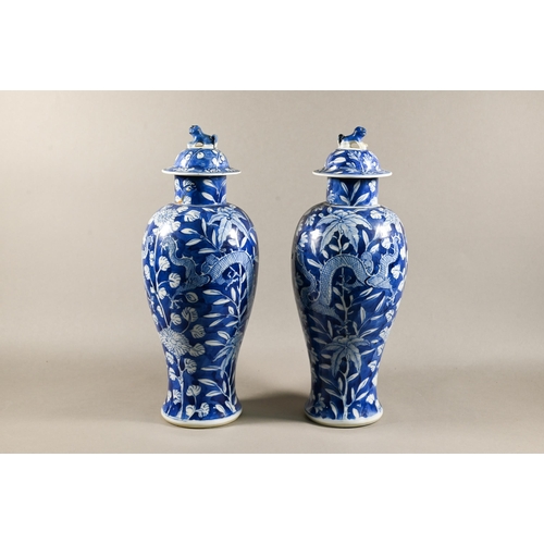 513 - A pair of 19th century Chinese blue and white vases with domed covers surmounted by guardian lion fi... 