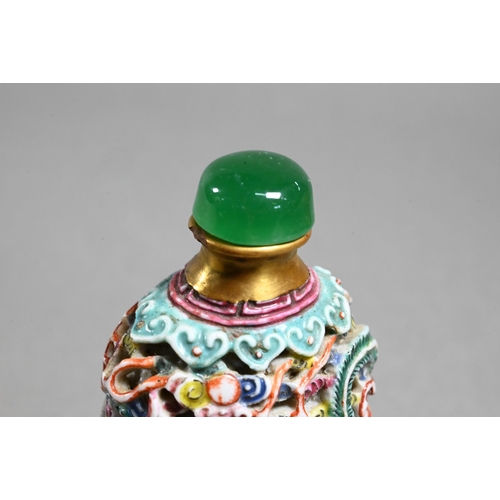 516 - A Chinese moulded porcelain famille rose snuff bottle with green glass stopper, modelled with a sinu... 