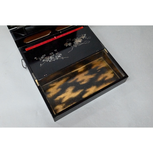 530 - An early 20th century Japanese black lacquered brass mounted writing box with twin hinged top and fi... 