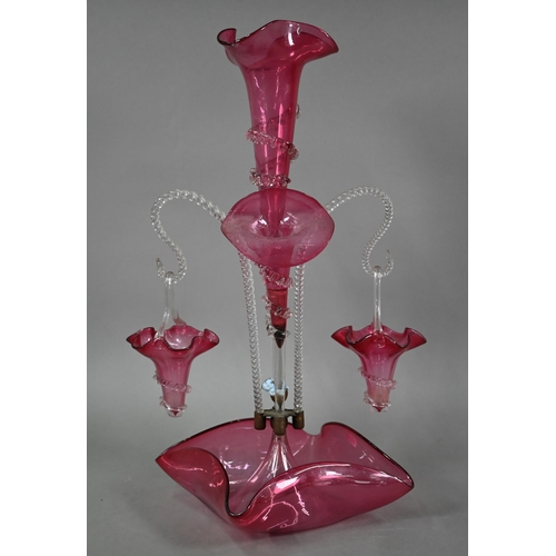 557 - A Victorian cranberry glass epergne with central flute vase flanked by two floral flutes and two bas... 