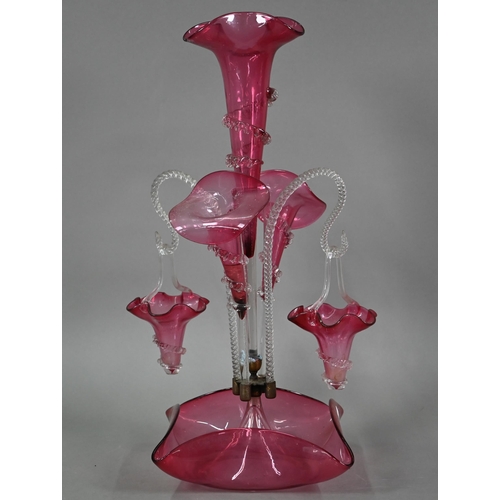 557 - A Victorian cranberry glass epergne with central flute vase flanked by two floral flutes and two bas... 