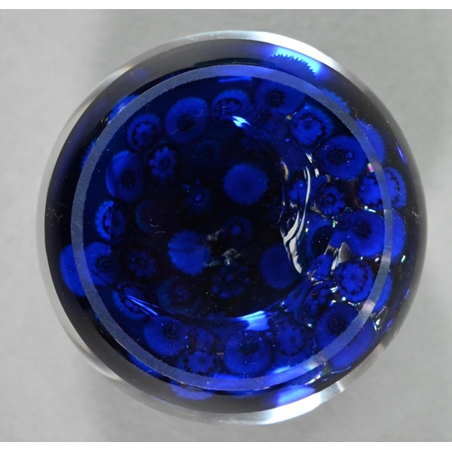 563 - A Clichy glass floral cane weight on a blue ground, 7.2 cm diam