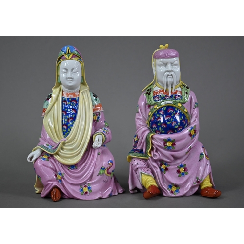 574 - A pair of Dresden figures of a Chinese couple in pink official's robes painted with flowers and bird... 