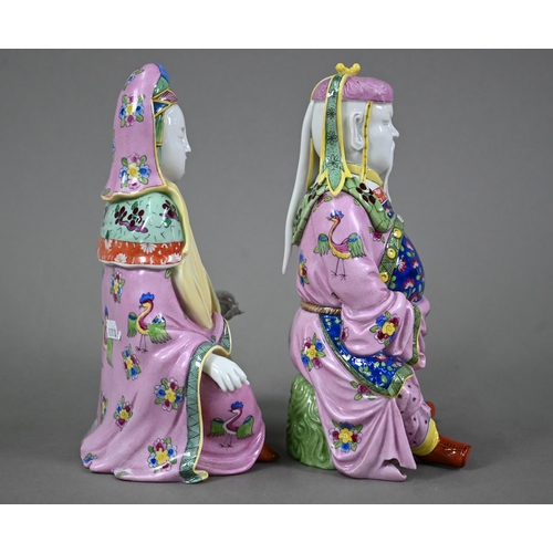 574 - A pair of Dresden figures of a Chinese couple in pink official's robes painted with flowers and bird... 