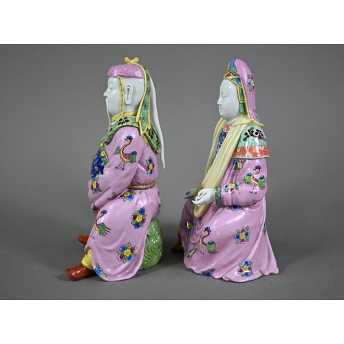 574 - A pair of Dresden figures of a Chinese couple in pink official's robes painted with flowers and bird... 