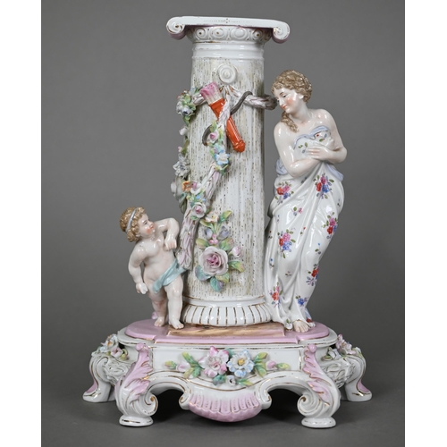 578 - A German porcelain pedestal, modelled with a shy maiden playing hide and seek with Cupid around a fl... 