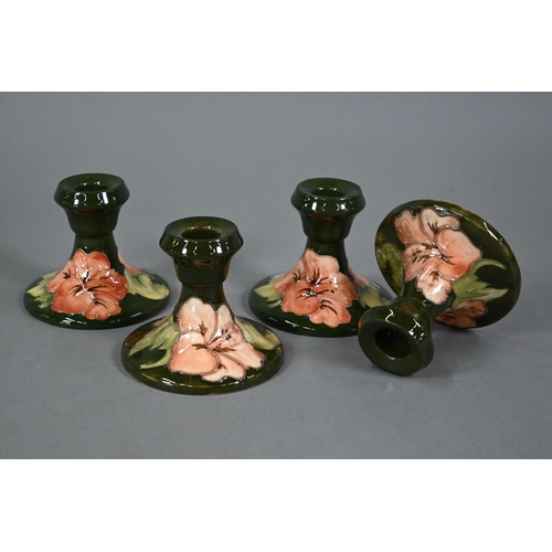 605 - A set of four Moorcroft green hibiscus candlesticks, with impressed stamps (one with paper 'Late Que... 