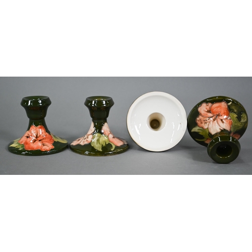 605 - A set of four Moorcroft green hibiscus candlesticks, with impressed stamps (one with paper 'Late Que... 